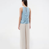 Sleeveless top in blue in lustrous satin. The Valdomd Top features a round neckline, vertical stitching detail at the front, and a button closure at the back for an elegant look. Made from 98% recycled polyester&nbsp;