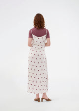 Long white satin dress with polka dots. The Vanjamd Print Dress features delicate spaghetti straps, a cowl neckline, and a loose, elegant drape that creates a feminine and modern look.
