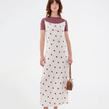 Long white satin dress with polka dots. The Vanjamd Print Dress features delicate spaghetti straps, a cowl neckline, and a loose, elegant drape that creates a feminine and modern look.