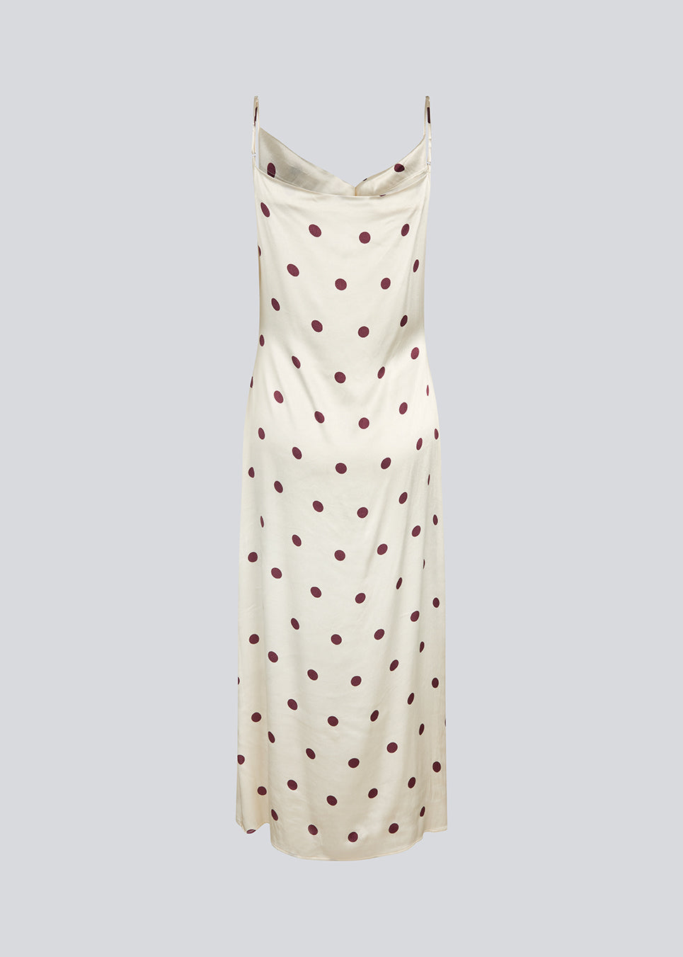 Long white satin dress with polka dots. The Vanjamd Print Dress features delicate spaghetti straps, a cowl neckline, and a loose, elegant drape that creates a feminine and modern look.