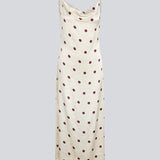 Long white satin dress with polka dots. The Vanjamd Print Dress features delicate spaghetti straps, a cowl neckline, and a loose, elegant drape that creates a feminine and modern look.