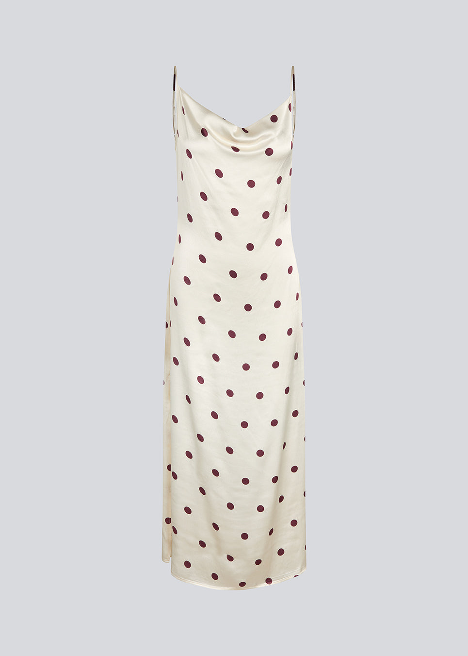 Long white satin dress with polka dots. The Vanjamd Print Dress features delicate spaghetti straps, a cowl neckline, and a loose, elegant drape that creates a feminine and modern look.