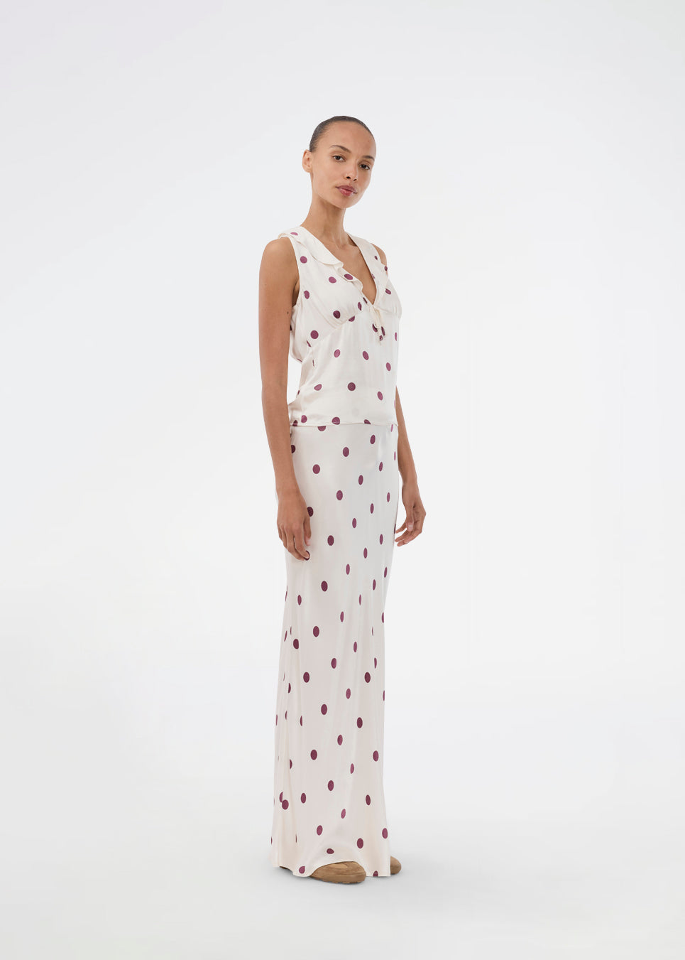 Long white satin skirt with polka dots. The Vanjamd Print Skirt features a loose, elegant drape and an elastic waistband for a comfortable and feminine look. Perfect for both everyday and evening outfits.