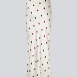 Long white satin skirt with polka dots. The Vanjamd Print Skirt features a loose, elegant drape and an elastic waistband for a comfortable and feminine look. Perfect for both everyday and evening outfits.