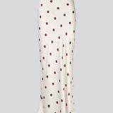 Long white satin skirt with polka dots. The Vanjamd Print Skirt features a loose, elegant drape and an elastic waistband for a comfortable and feminine look. Perfect for both everyday and evening outfits.