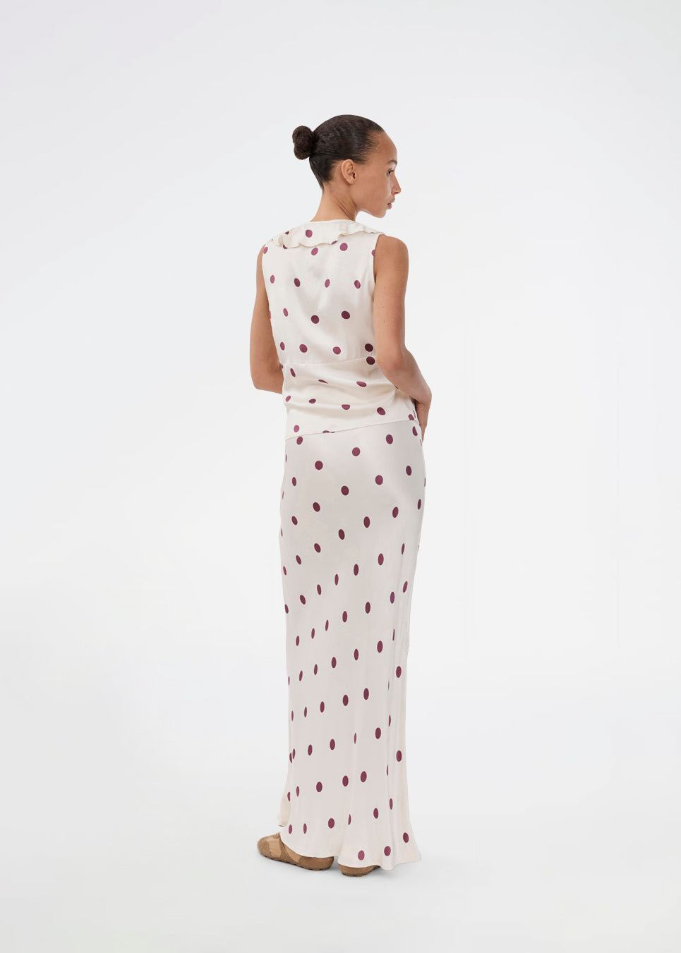 Polka-dotted sleeveless top with a ruffle trim. The Vanjamd Print Top is made from lustrous satin and features feminine details such as a V-neckline, ruching, and a tie detail under the bust for an elegant look.