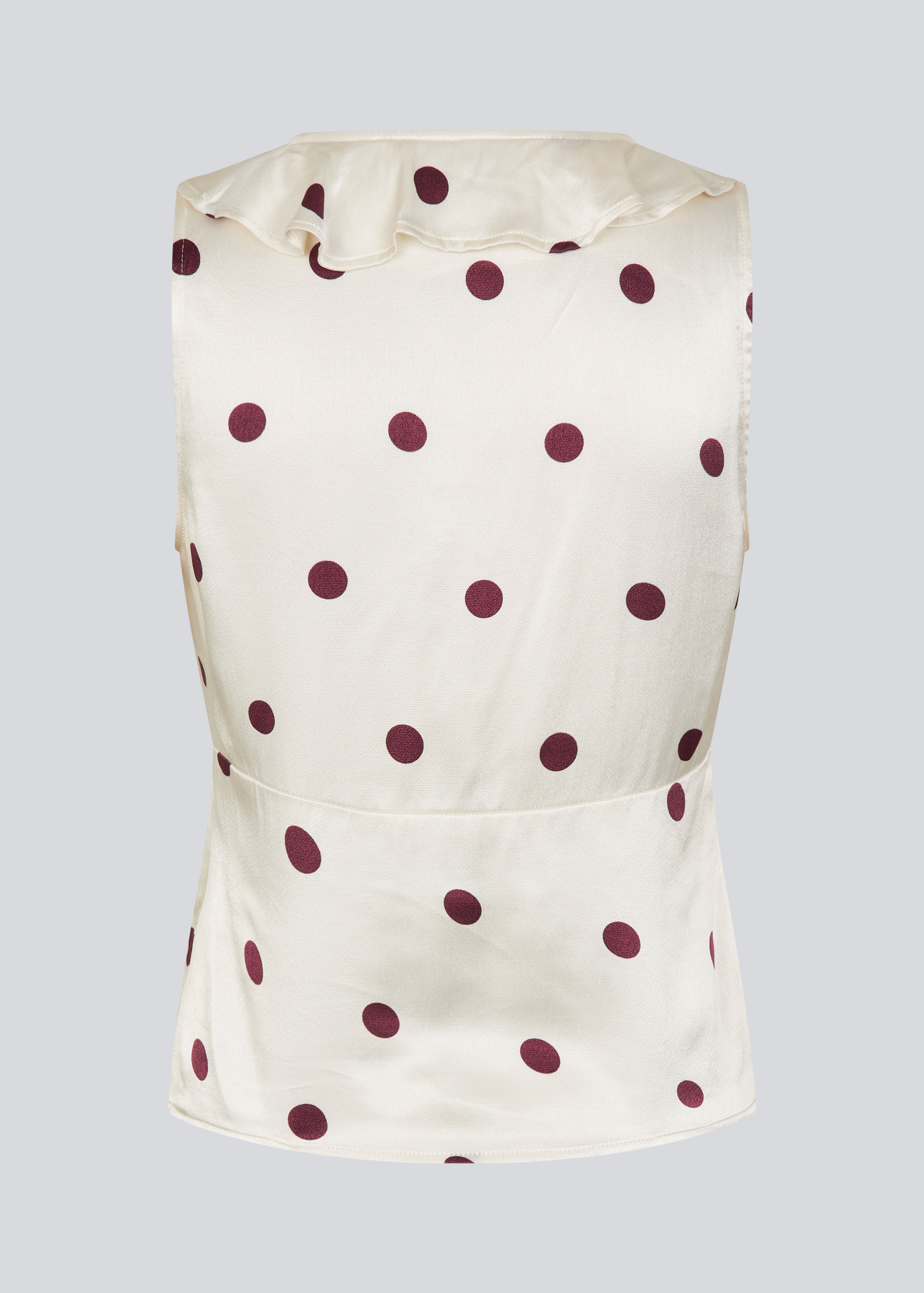 Polka-dotted sleeveless top with a ruffle trim. The Vanjamd Print Top is made from lustrous satin and features feminine details such as a V-neckline, ruching, and a tie detail under the bust for an elegant look.