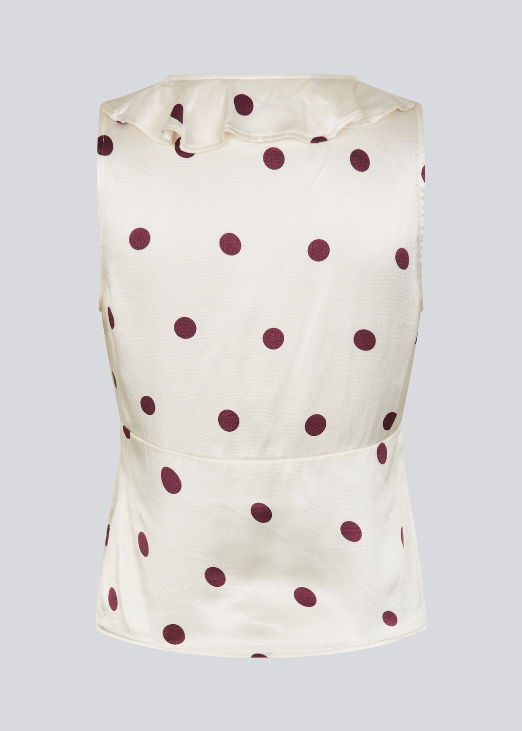 Polka-dotted sleeveless top with a ruffle trim. The Vanjamd Print Top is made from lustrous satin and features feminine details such as a V-neckline, ruching, and a tie detail under the bust for an elegant look.