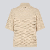 Elegant and lightweight cardigan in beige in a beautifully knitted openwork pattern. The VesterMD cardigan features short sleeves, a collar, and an adjustable drawstring closure at the front, creating a feminine and relaxed look. Made from 100% organic cotton for soft and breathable comfort.