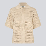 Elegant and lightweight cardigan in beige in a beautifully knitted openwork pattern. The VesterMD cardigan features short sleeves, a collar, and an adjustable drawstring closure at the front, creating a feminine and relaxed look. Made from 100% organic cotton for soft and breathable comfort.