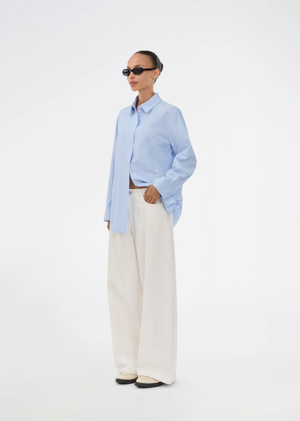 Long, classic blue striped shirt. The ViggeMD Stripe Shirt features timeless details such as a collar, button closure, and cuffs, along with a high slit at the back that adds a modern twist to the otherwise simple design. The model is 175 cm and wears a size S/36.


Material:
50% Organic Cotton
50% Polyester