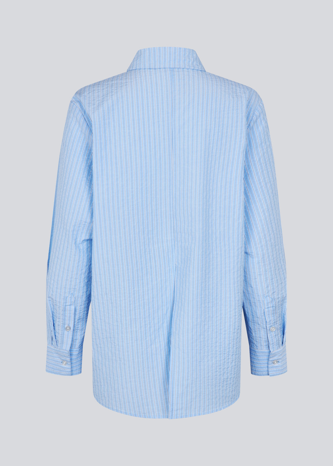 Long, classic blue striped shirt. The ViggeMD Stripe Shirt features timeless details such as a collar, button closure, and cuffs, along with a high slit at the back that adds a modern twist to the otherwise simple design. The model is 175 cm and wears a size S/36.


Material:
50% Organic Cotton
50% Polyester