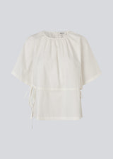 Vilbertmd top is designed with soft pleats at the neckline, short wide sleeves, and a side tie detail that creates a relaxed yet refined look. An elegant style that can easily be dressed up or down in the modern wardrobe.