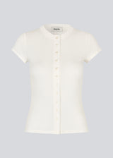 Ribbed white T-shirt with front buttons. The VilsonMD T-shirt features short sleeves, a fitted silhouette, and a hip-length cut. A modern and feminine T-shirt that combines classic details with a timeless, elegant look.