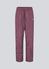 Tracksuitpants in purple in 100% recycled nylon. Volmermd pants have piping along the sideseam and cutline details for a sporty look.