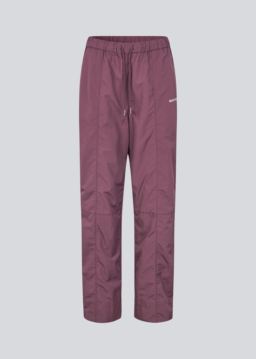 Tracksuitpants in purple in 100% recycled nylon. Volmermd pants have piping along the sideseam and cutline details for a sporty look.