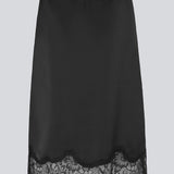 Black satin skirt with lace hem on a light gray background