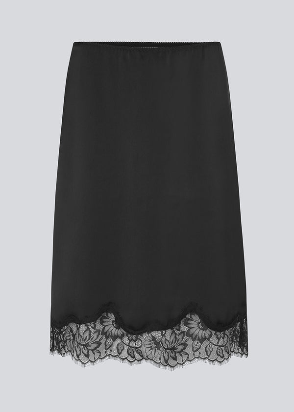 Elegant satin skirt in black with lace details on the bottom. Vuemd skirt is a knee-length satin style with an elastic waist and a relaxed fit. Perfect worn alone or layered for versatile styling.