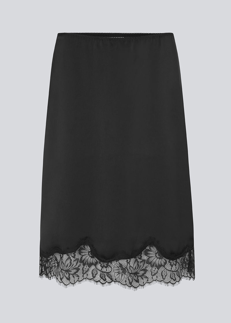 Elegant satin skirt in black with lace details on the bottom. Vuemd skirt is a knee-length satin style with an elastic waist and a relaxed fit. Perfect worn alone or layered for versatile styling.