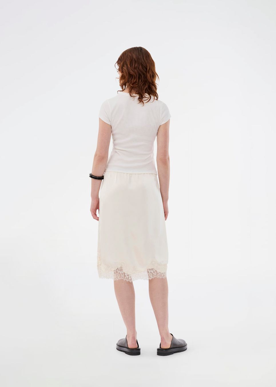 Elegant satin skirt in white/cream with lace details. VueMD skirt is a knee-length satin style with an elastic waist and a relaxed fit. Perfect worn alone or layered for versatile styling.&nbsp;