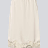 Elegant satin skirt in white/cream with lace details. VueMD skirt is a knee-length satin style with an elastic waist and a relaxed fit. Perfect worn alone or layered for versatile styling.&nbsp;