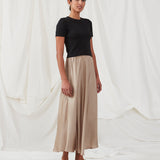 Long beige skirt with wide skirt. DevanMD skirt is designed in a shiny satin material with elasticated medium waist. The model is 177 cm and wears a size S/36.'