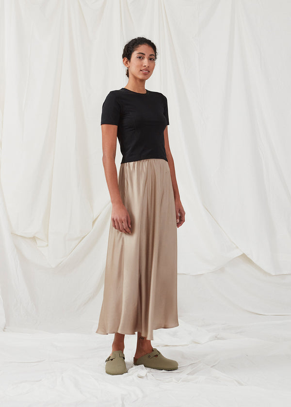 Long beige skirt with wide skirt. DevanMD skirt is designed in a shiny satin material with elasticated medium waist. The model is 177 cm and wears a size S/36.'