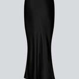 Black long wide satin skirt. Parveenmd skirt has an elastic waistband. The model is 175 cm and wears a size s/36.