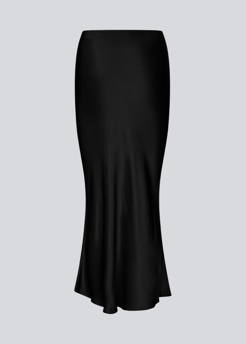 Black long wide satin skirt. Parveenmd skirt has an elastic waistband. The model is 175 cm and wears a size s/36.