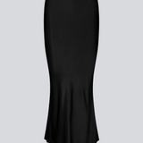 Black long wide satin skirt. Parveenmd skirt has an elastic waistband. The model is 175 cm and wears a size s/36.