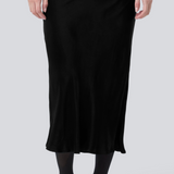 Black long wide satin skirt. Parveenmd skirt has an elastic waistband. The model is 175 cm and wears a size s/36.