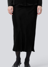 Black long wide satin skirt. Parveenmd skirt has an elastic waistband. The model is 175 cm and wears a size s/36.