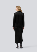Black long wide satin skirt. Parveenmd skirt has an elastic waistband. The model is 175 cm and wears a size s/36.
