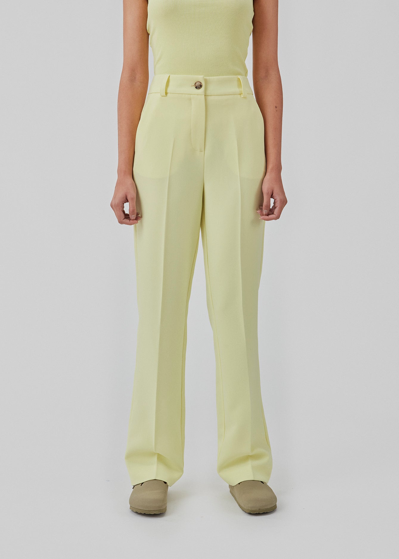 Gale pants i gul har et klassisk design. Buksen har lige, vide ben med pressefolder som skaber et elegant udtryk. Indersøm (S/36): 83 cm Bukserne forlænges med 0,5 cm for hver størrelse.