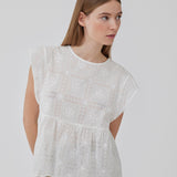 Top i broderie anglaise af bomuld med overskæring under brystet med ekstra vidde. HollynMD top har rund hals, korte ærmer og lille åbning med knap bagpå. Modellen er 175 cm og har en størrelse S/36 på.