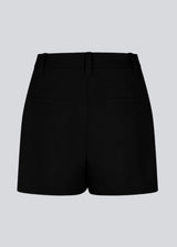 Black high-waisted shorts with side pockets. NormaMD shorts have a zip fly and button, belt loops, and decorative paspoil pockets on the back.