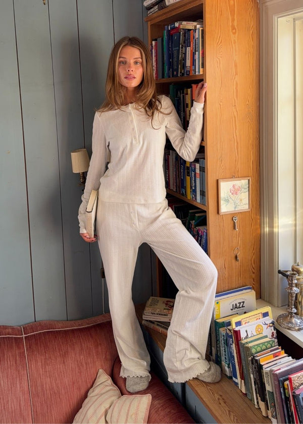 White pointelle pants. Josefinemd pants are feminine pointelle cotton trousers with lace trim and a subtle openwork pattern. Soft, comfortable, and ideal for relaxing at home. Josefine Vogt (165 cm) and the model (177 cm) are both wearing size Small.