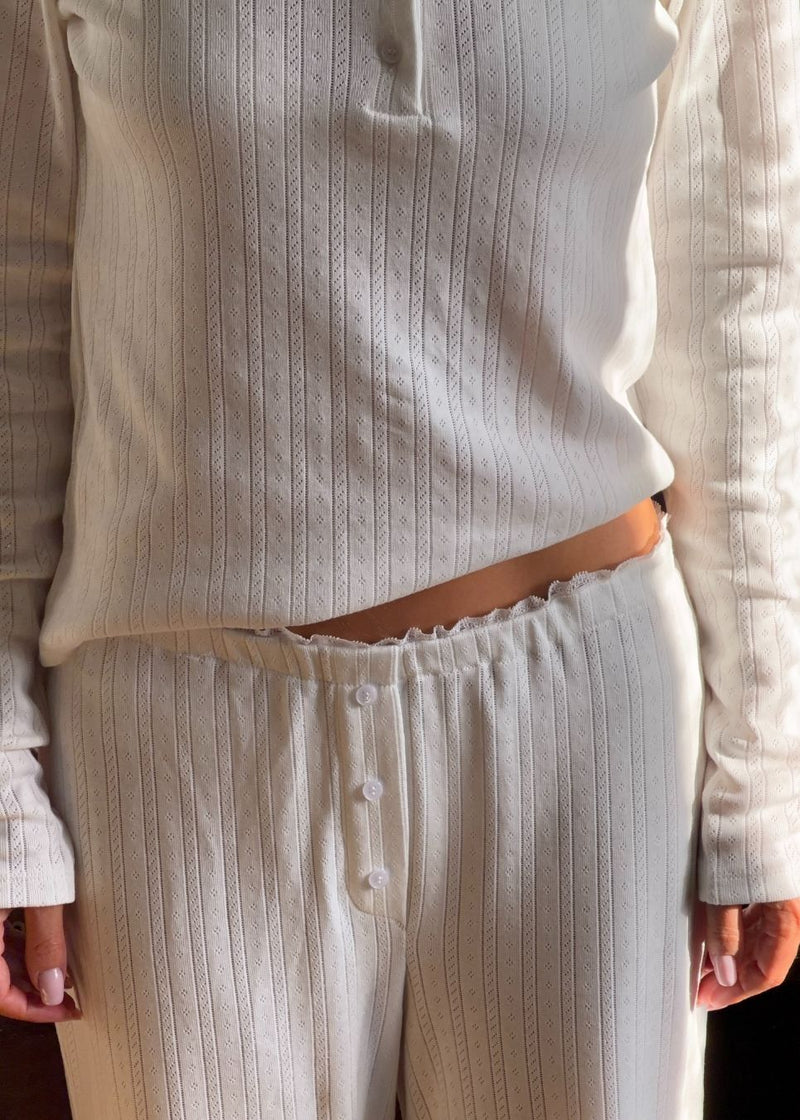 White pointelle pants. Josefinemd pants are feminine pointelle cotton trousers with lace trim and a subtle openwork pattern. Soft, comfortable, and ideal for relaxing at home. Josefine Vogt (165 cm) and the model (177 cm) are both wearing size Small.