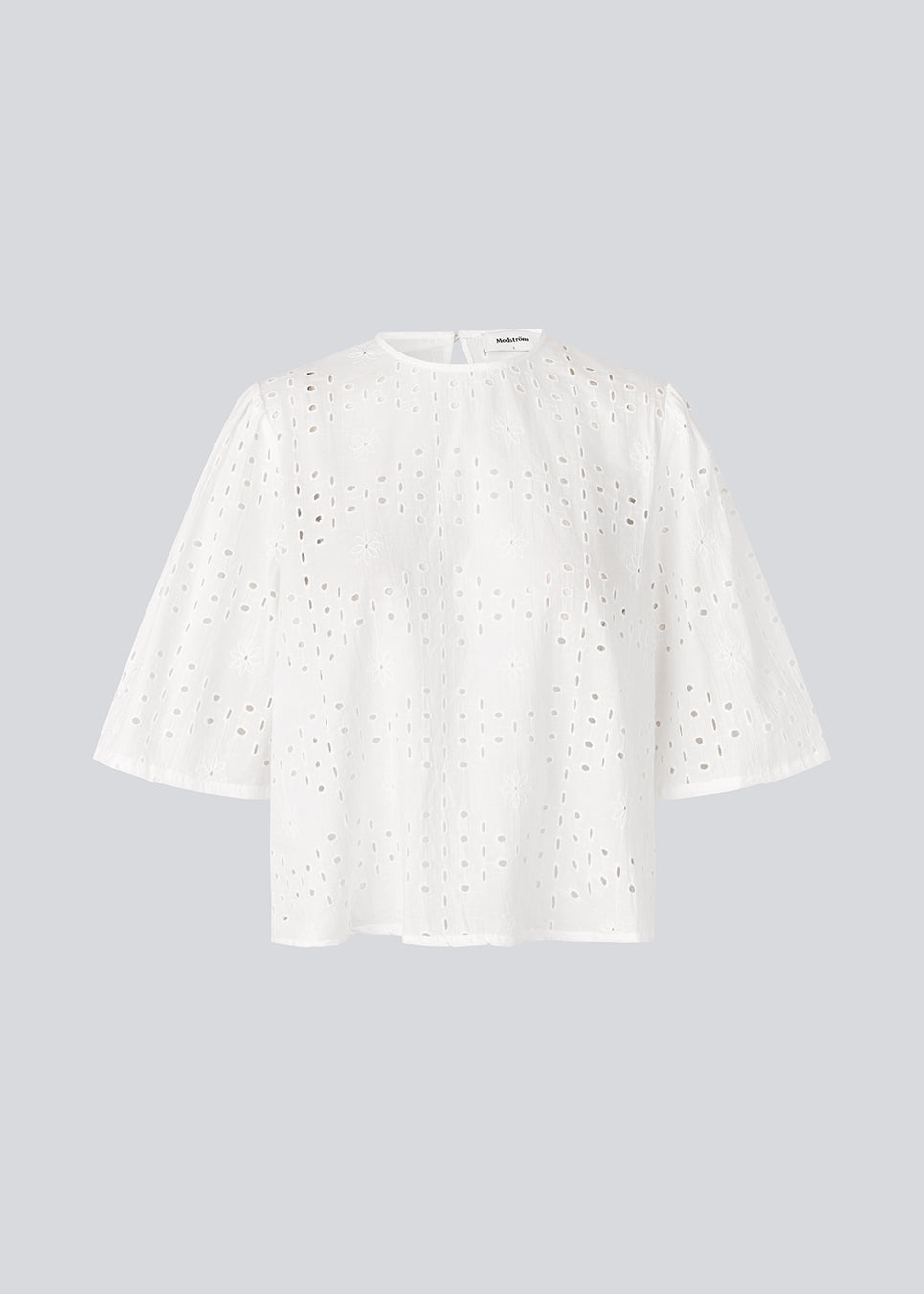 Top med korte ærmer i broderie anglaise. MisoMD top har en løs pasform og en slids med knappelukning i ryggen. 