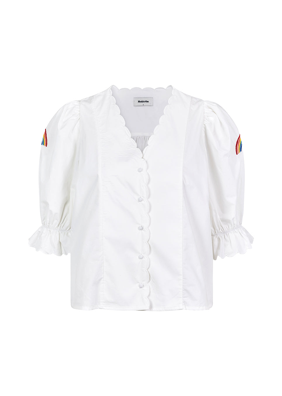 Bluse i sprød økologisk bomuld med pufærmer med brodering, knapper fortil og bølgede pyntekanter. PernilleMD shirt har v-formet udskæring og knapper langs forstykket.