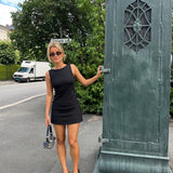 Fitted black mini dress in an A-line shape with a round neck and no sleeves. JosefineMD tank flare dress is made from a stretchy material. The model is 177 cm and wears a size S/36.