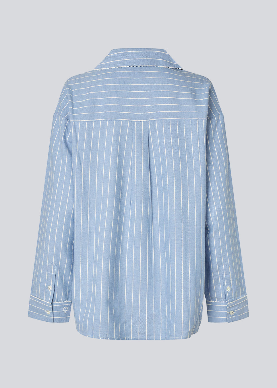 Blue classic striped pyjamas. The pyjamas is sold as a set of shirt and pants in the same size. Josefinemd pyjamas are made from 100% soft cotton and feature a classic fit with a collar, button closure, and drawstring trousers. Finished with delicate wave trim and comes with a matching pouch with logo. Josefine Vogt (165 cm) and the model (177 cm) are both wearing size Small.