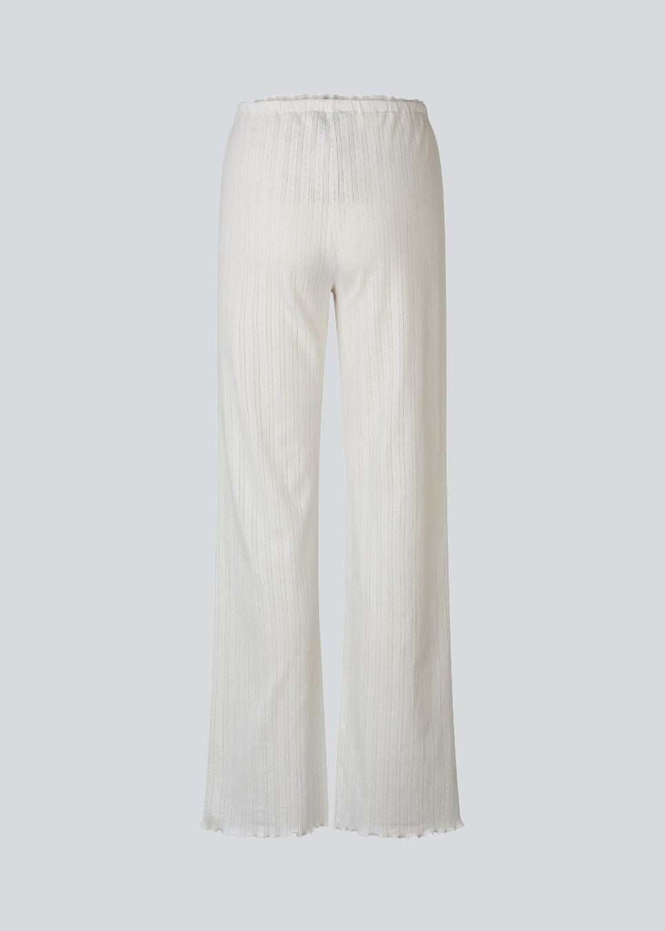 White pointelle pants. Josefinemd pants are feminine pointelle cotton trousers with lace trim and a subtle openwork pattern. Soft, comfortable, and ideal for relaxing at home. Josefine Vogt (165 cm) and the model (177 cm) are both wearing size Small.