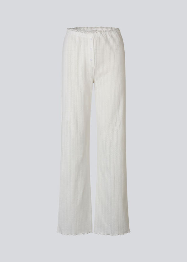 White pointelle pants. Josefinemd pants are feminine pointelle cotton trousers with lace trim and a subtle openwork pattern. Soft, comfortable, and ideal for relaxing at home. Josefine Vogt (165 cm) and the model (177 cm) are both wearing size Small.