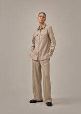 Beige long shirt with folded details in front. KalemMD shirt has two chest pockets, button closure in front and slits in the side seams.