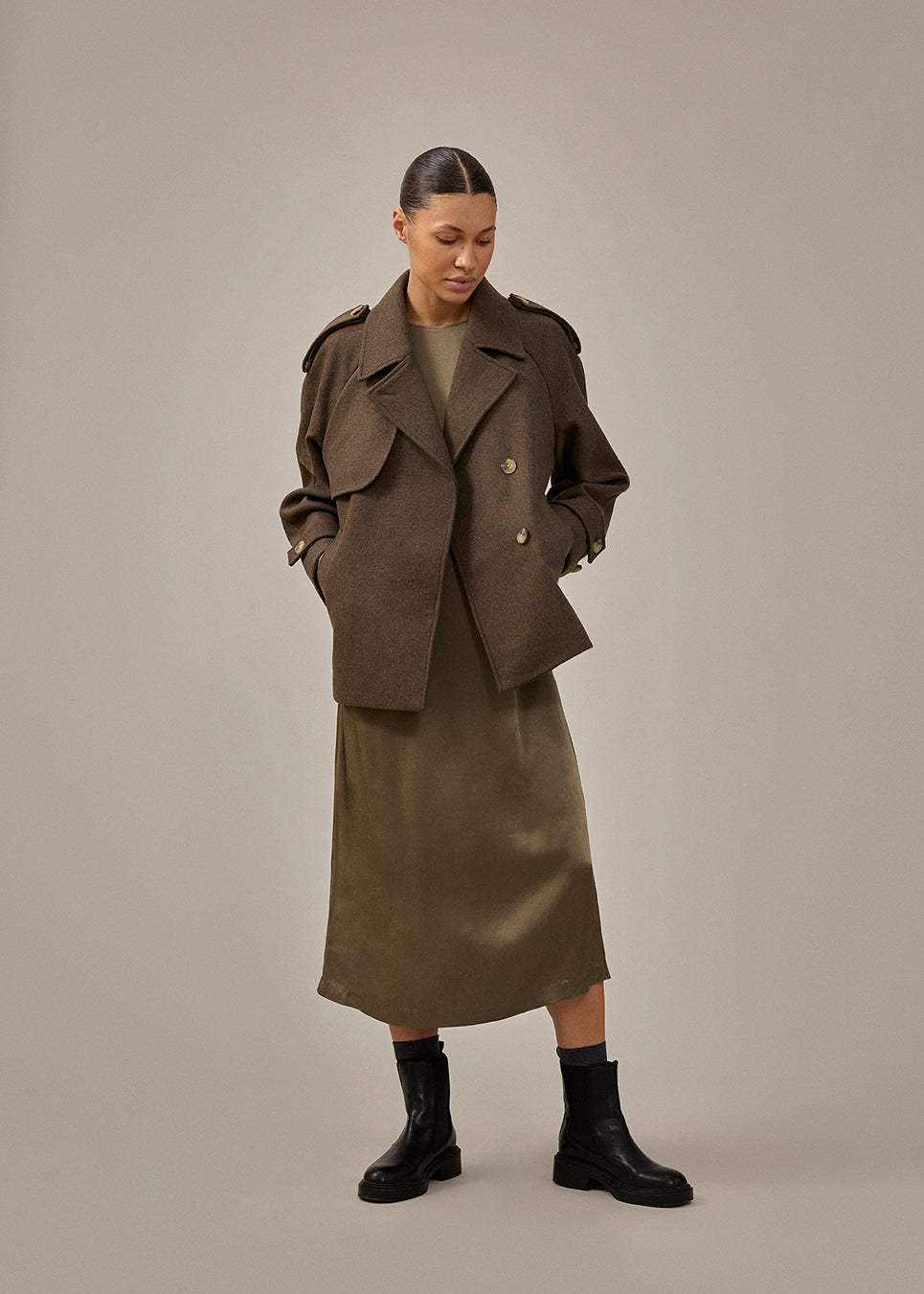 Cropped double-breasted wool coat in a brown color with hidden buttons. EsmundMD jacket has classic coat details with raglan sleeves and an high yoke at the back. Lined. The model is 175 cm and wears a size S/36.