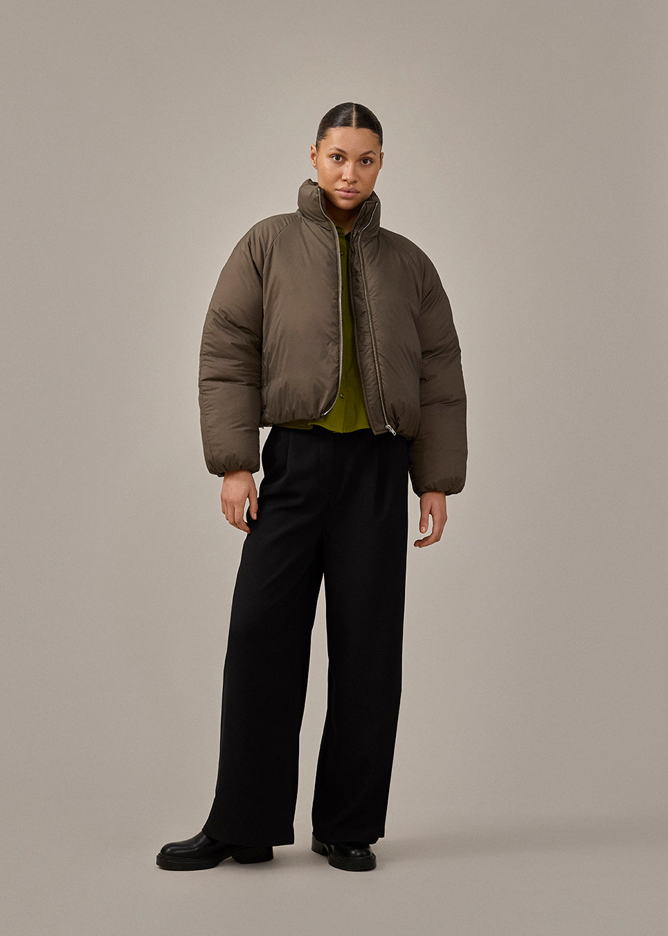 Slightly cropped brown puffer with a high neck. JoniMD jacket has side pockets, elastic at the sleeves and an adjustable string at the hem.