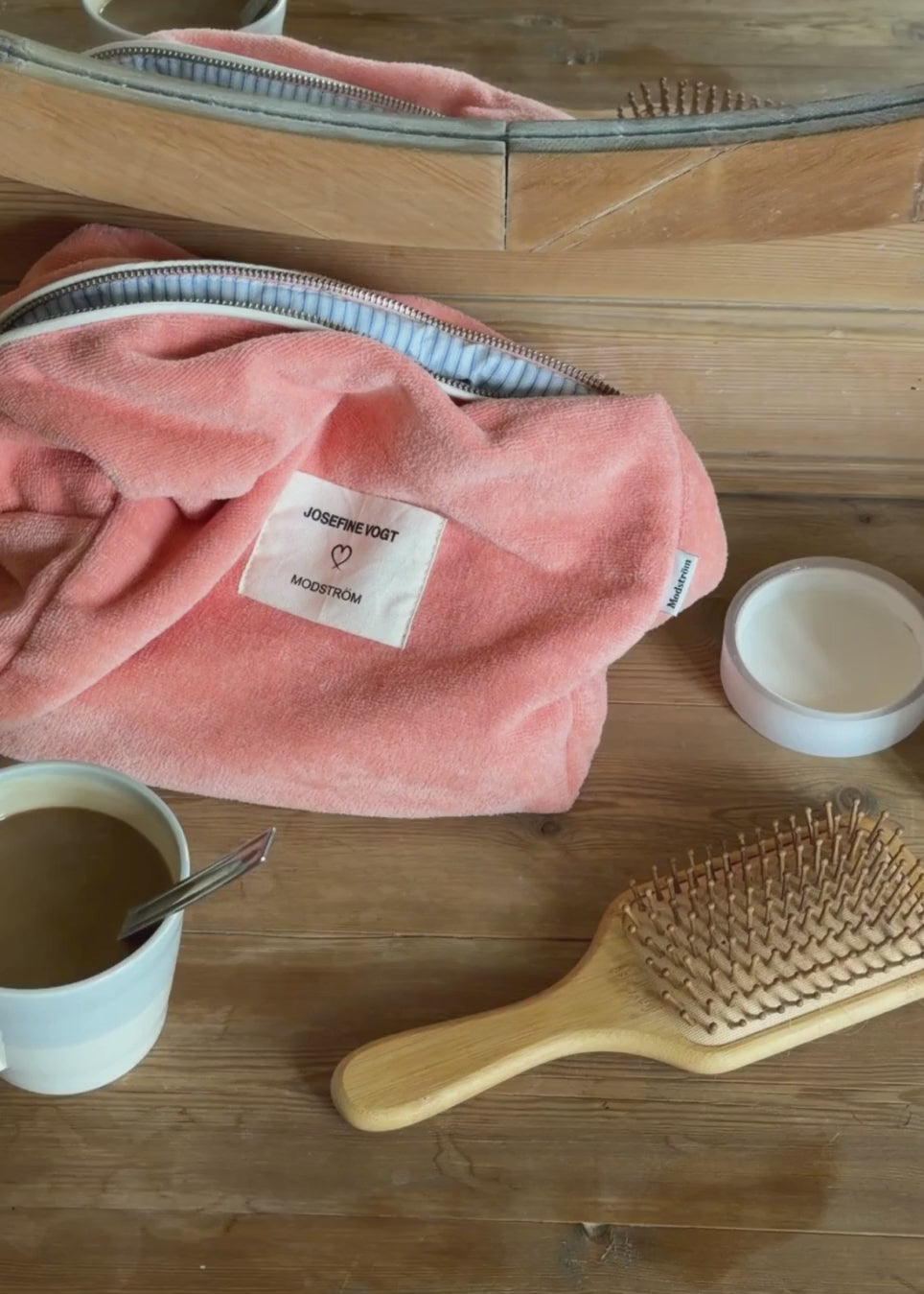 Peach colored toiletry bag with a sewn-on logo. Josefinemd toiletry bag is minimalist and made from organic cotton with a light blue lining and zip closure. Practical and elegant – a must-have for travel or the bathroom.
