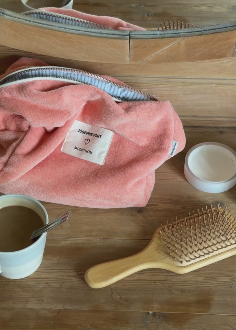 Peach colored toiletry bag with a sewn-on logo. Josefinemd toiletry bag is minimalist and made from organic cotton with a light blue lining and zip closure. Practical and elegant – a must-have for travel or the bathroom.
