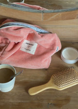 Peach colored toiletry bag with a sewn-on logo. Josefinemd toiletry bag is minimalist and made from organic cotton with a light blue lining and zip closure. Practical and elegant – a must-have for travel or the bathroom.
